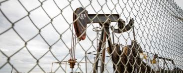 An oil pump behind a fence.