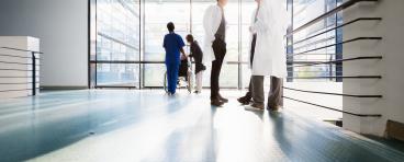 Doctors converse in a corridor.