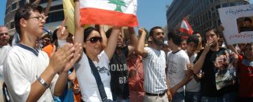 A protester holds up the Lebanese flag amongst other protesters.