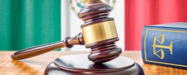 A gavel rests in front of the Mexican flag.