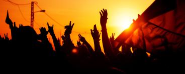 Hands raise up against a sunset.