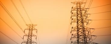 Transmission towers against a sunset.