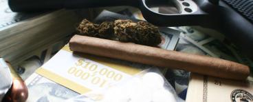 Drugs and a gun with money in a pile