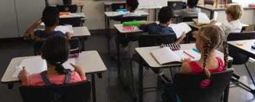 Children sit at desks in school