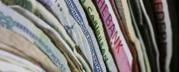 International paper currencies stacked together, showing range of colors and styles