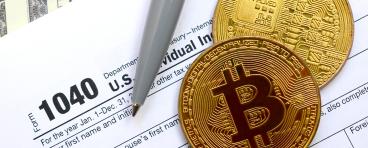 Bitcoins lie on an income tax form.