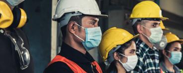 Construction workers wear masks.