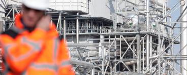 Inspector with refinery facility in background