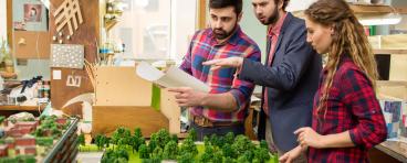 Landscape designers having discussion about city layout model 