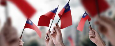  A group of people holding small flags of the Taiwan in their hands