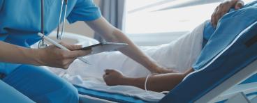 Physician holds patient's hand while encouraging and providing medical advice.