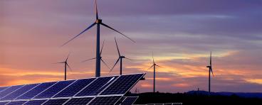 Solar panels in front of wind turbines