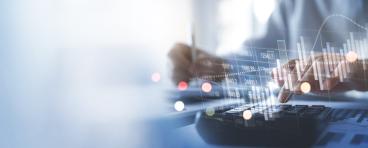 financial information superimposed over hands above keyboard