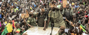 Members of the Malian junta wave as civilians gather to celebrate the overthrow of the president on Aug. 21, 2020.