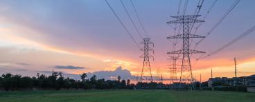 Group silhouette of transmission towers at dusk