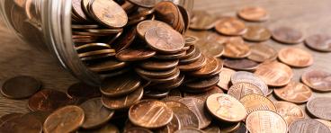 Glass jar with coins on table