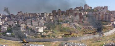 Israel and Palestine divided by wall with smoke and fire pisgat zeev and anata refugees camp, Jerusalem Israel-Aerial view