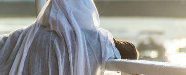  Licensed Find Similar File #:  94934002 Muslim woman on the fence of a boat overlooking the sea at sunset