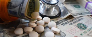 Pill bottle with pills and dollar bill rolls inside