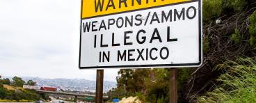 Road sign near U.S.-Mexico border that says "Warning: Weapons/ammo illegal in Mexico"