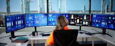 Woman watching oil and gas infrastructure monitors