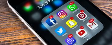 Apple iPhone 7 on wooden table with icons of social media