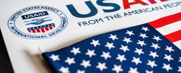 USAID logo letterhead and US flag in foreground 
