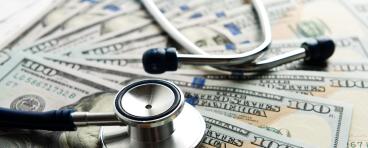 Stethoscope on top of U.S. bills