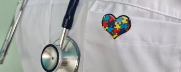 A Doctor Wearing a Stethoscope and a Puzzle Piece Heart Pin.