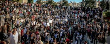 Unrecognizable crowd of ethnic protesters during rally on city street