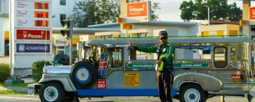 Traffic officer manages jeepney at petrol station