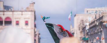 Foto de la bandera de México entre la gente en el centro histórico de Morelia.