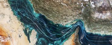 Satellite view of the Persian Gulf and Strait of Hormuz with glowing blue lines symbolizing naval traffic and strategic maritime routes amidst geopolitical tensions and regional conflict in Iran.
