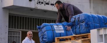  A man unloads humanitarian aid supplied by the U.N. refugee agency UNHCR at a school in Beirut used as a shelter for people displaced by Israeli airstrikes.