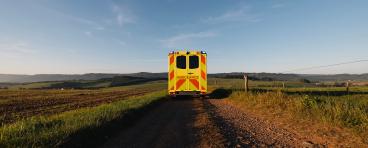 Yellow ambulance on a dirt road: medical transport in rural area